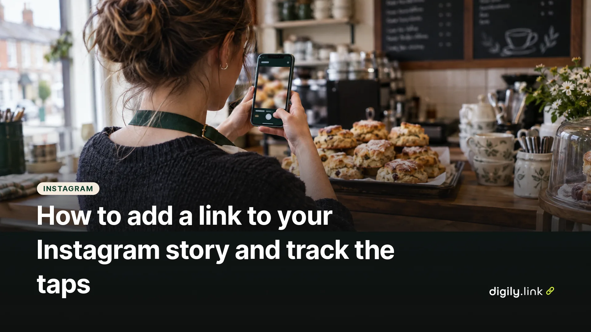 A café owner photographing a tray of scones on a phone behind the counter